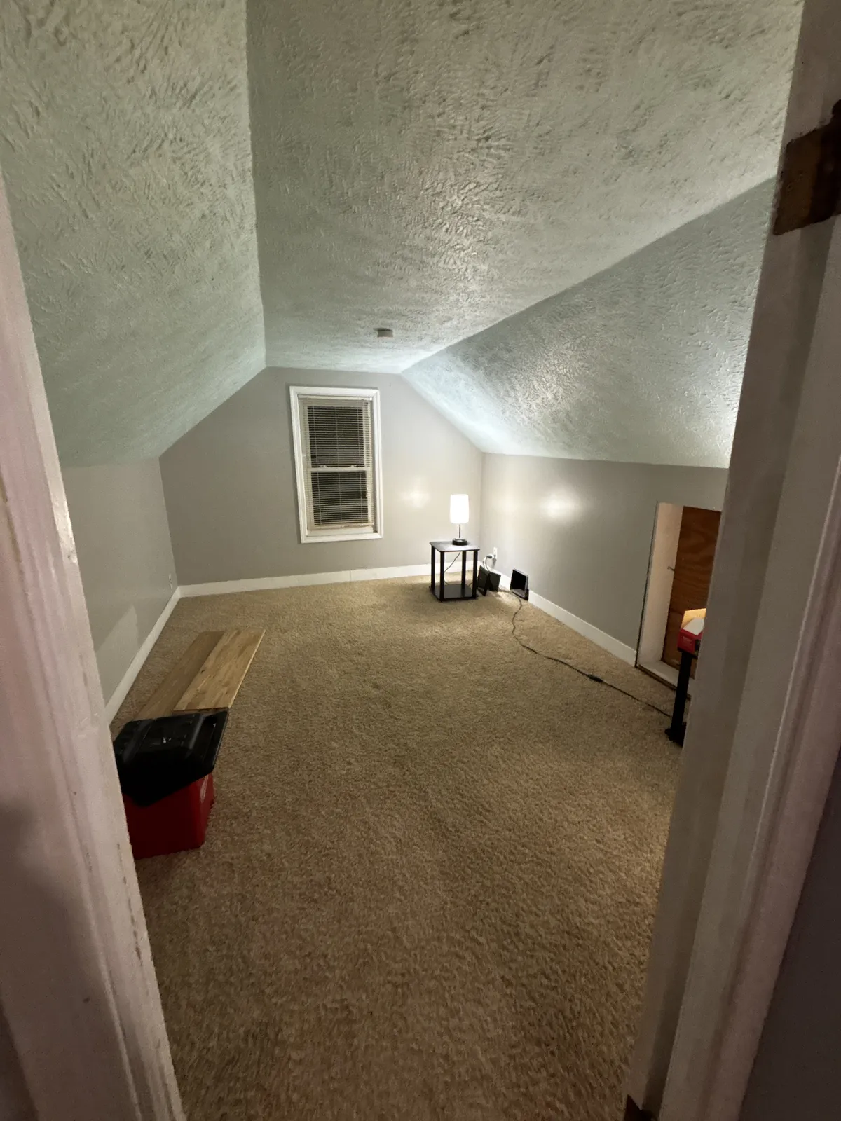 Upstairs bedroom with dated carpet and textured ceiling